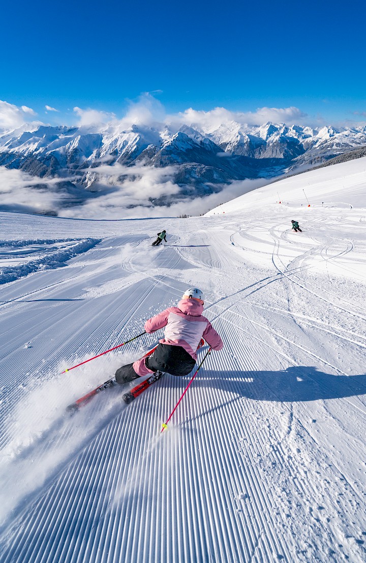Dynamisches Skivergnügen auf den frisch präparierten Pisten der Wildkogel-Arena – vor einer beeindruckenden Bergkulisse in den Hohen Tauern.